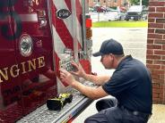 A fireman installs the license plate on the new engine 5