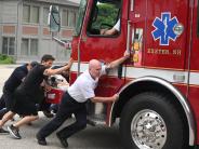 Fire Department Staff push a fire truck into the public safety complex during a push-in ceremony