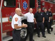 Assistant Fire Chief talks to a crowd in front of the fire engine 