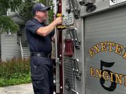 A fireman removes the license plate from the old engine 5