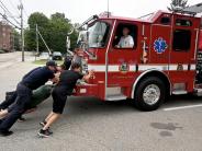 Fire Department Staff push a fire truck into the public safety complex during a push-in ceremony